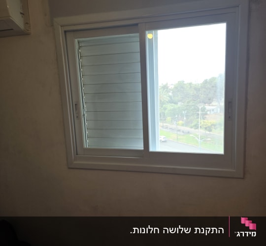 חלון הזזה בודד מאיכות אלומיניום לבן המותקן בחדר